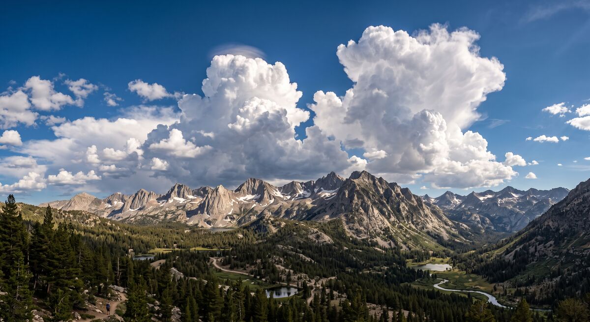 Afternoon cumulus clouds building over the Sierra Nevada mountain ridgeline in summer with natural lighting