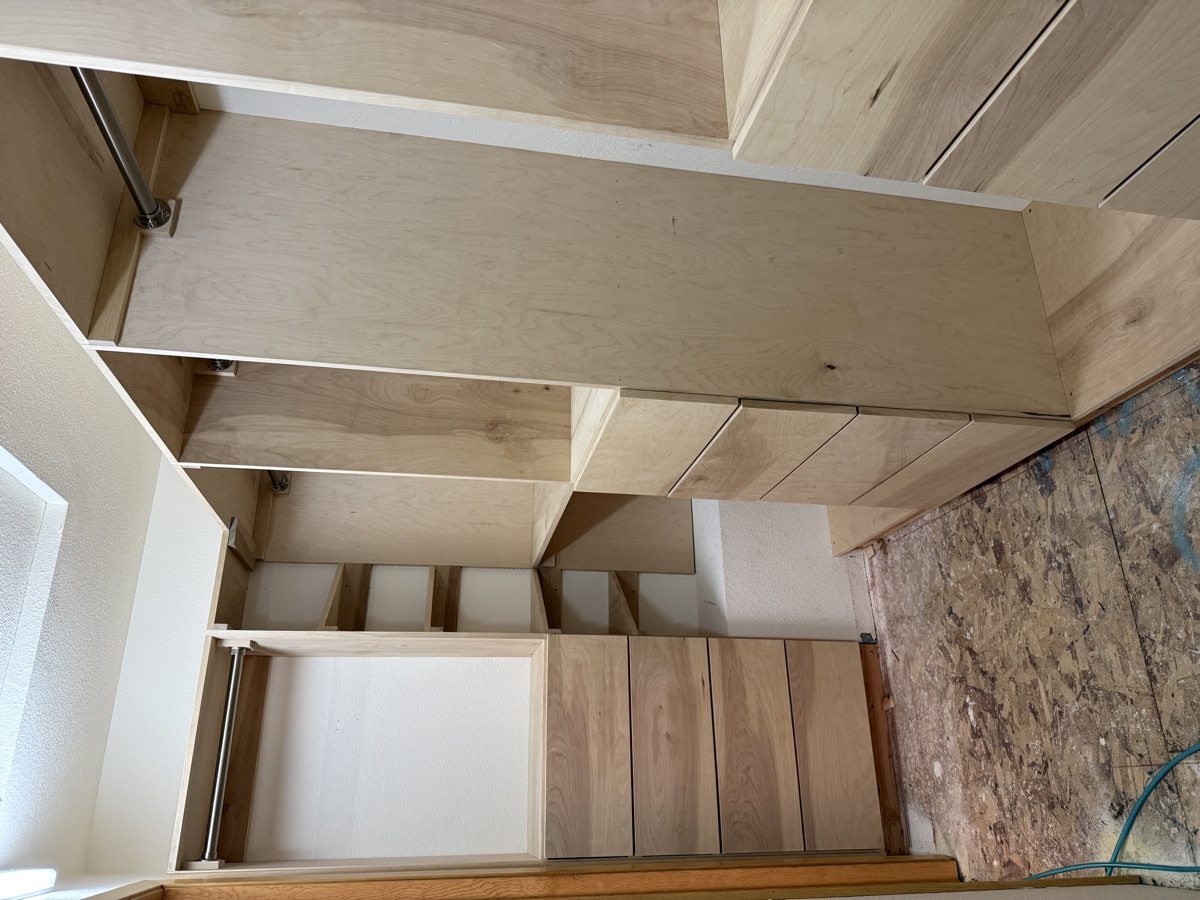 Completed walk-in closet with custom built-in shelving, drawers, and LED lighting — wide view